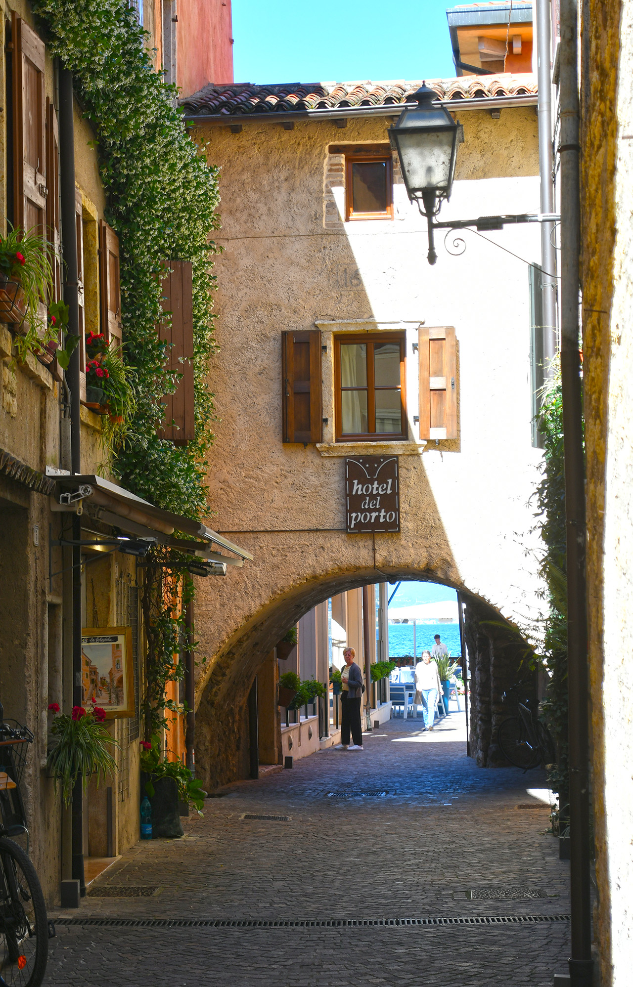 Vicolo medievale di Torri del Benaco con arco che inquadra il porto
